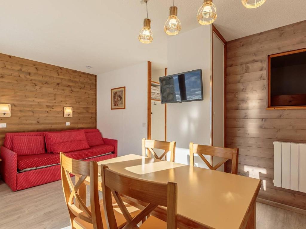 un salon avec une table et un canapé rouge dans l'établissement Charmant appart. skis aux pieds, terrasse sud, central, 4 pers, TV, parking, casier à ski - FR-1-351-148, à La Plagne Tarentaise