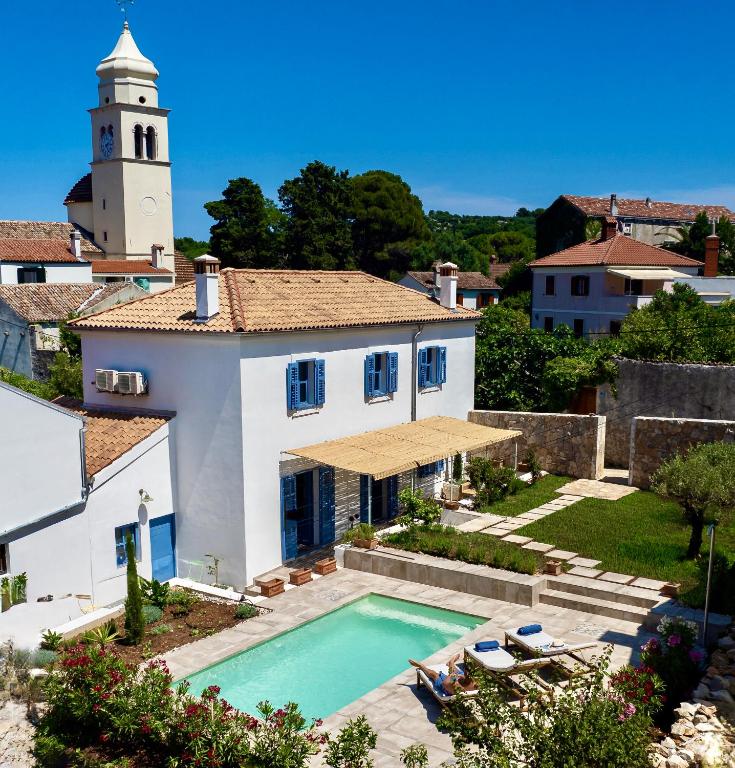 a villa with a swimming pool and a lighthouse at Casa Guarda Island Lošinj in Veli Lošinj