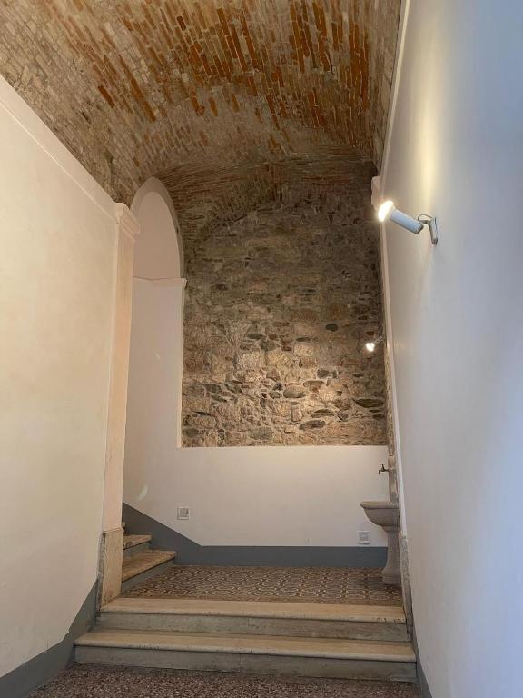 un corridoio con un muro di mattoni e una scala di Palazzo Antico ad Ascoli Piceno