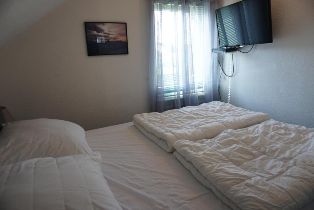 a bedroom with a large white bed and a window at Kustverhuur, Vakantiepark Fort Soleil 24 in Breskens