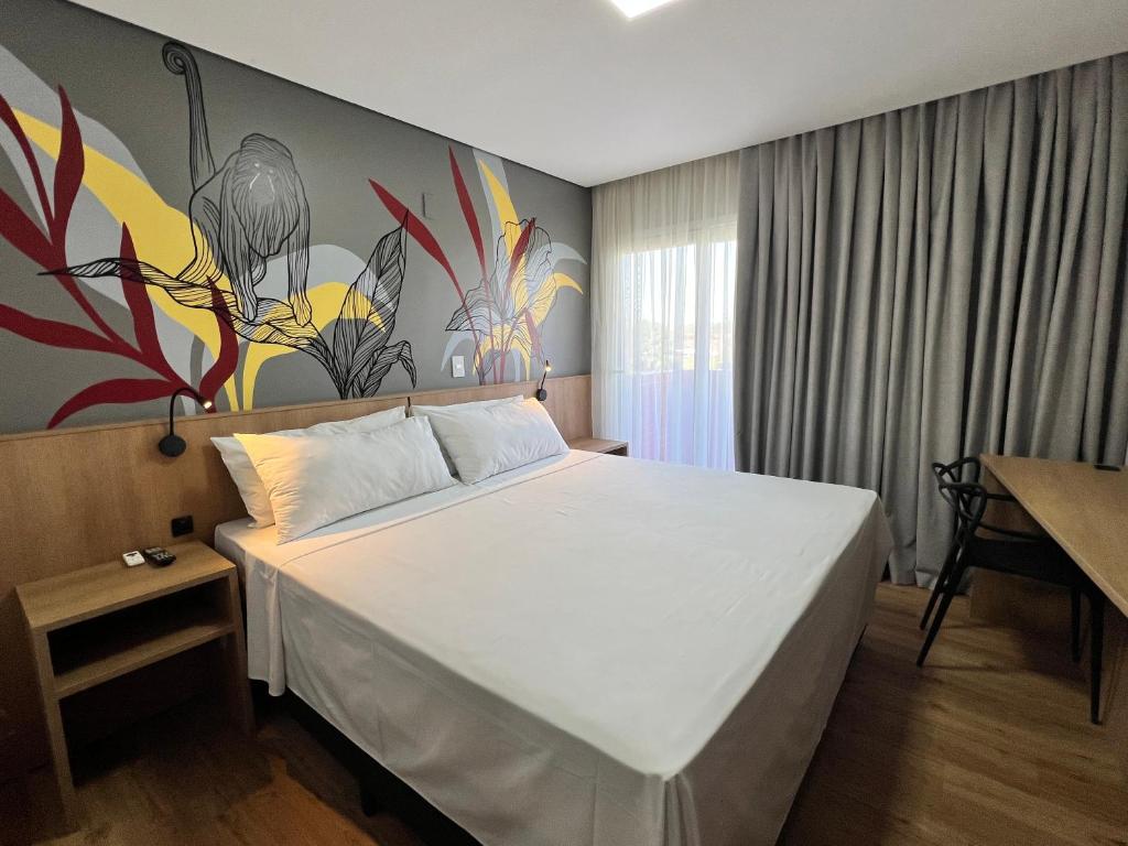 Postel nebo postele na pokoji v ubytování Ramada Encore Ponta Grossa