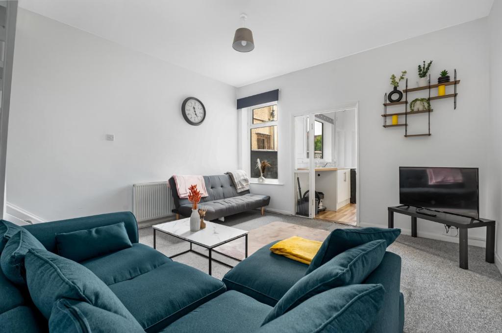 ein Wohnzimmer mit einem blauen Sofa und einem Tisch in der Unterkunft The Castle - Grimsby/Cleethorpes perfect for Contractors in Grimsby