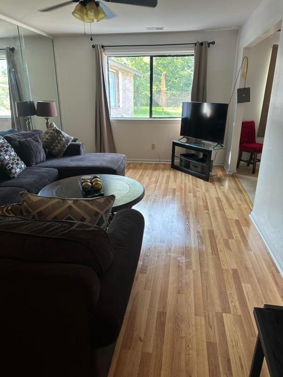 a living room with a couch and a flat screen tv at Serenity Retreat near Camp Lejeune & Beaches in Jacksonville