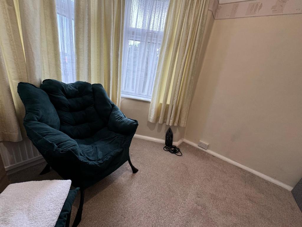 a black chair in a room with a window at 303 Upminster Road North in Rainham
