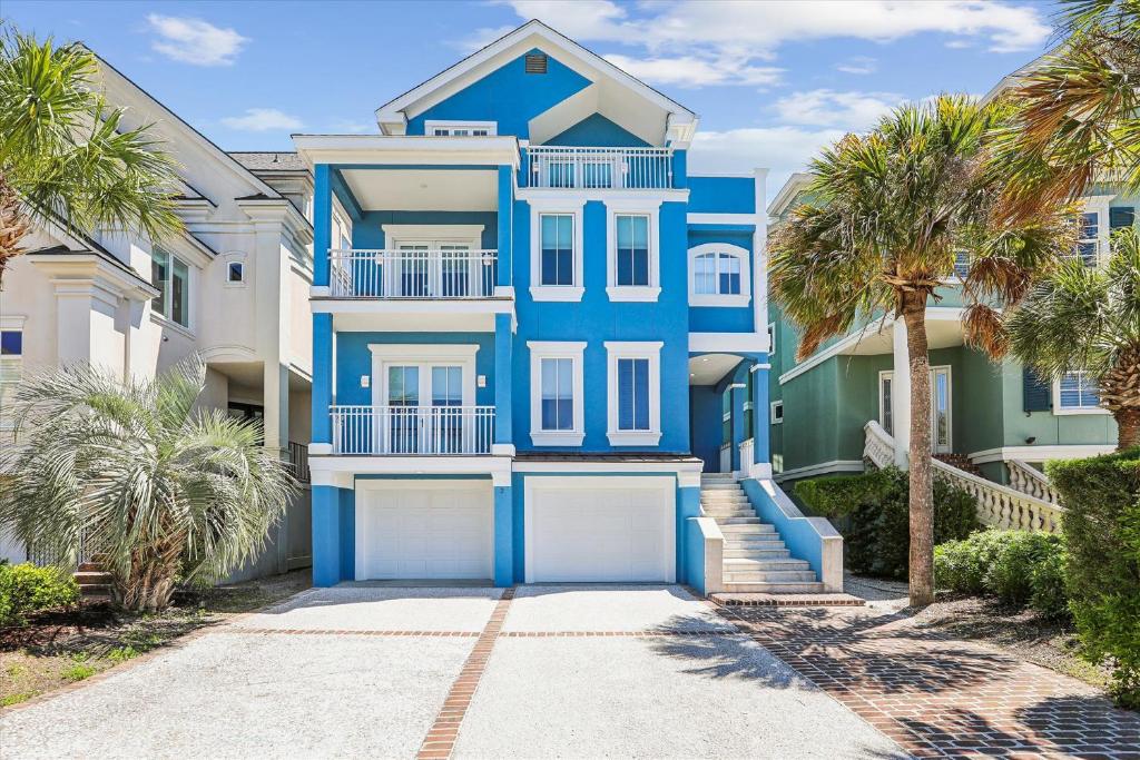 a blue house with palm trees in front of it at 2 Collier Beach- Oceanfront, Dog Friendly , Private Pool, FREE Activities in Hilton Head Island