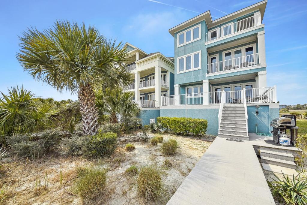 a house with a palm tree in front of it at 27 Singleton Beach- Oceanfront, Private Pool, Pool Table, FREE Activities Included in Hilton Head Island