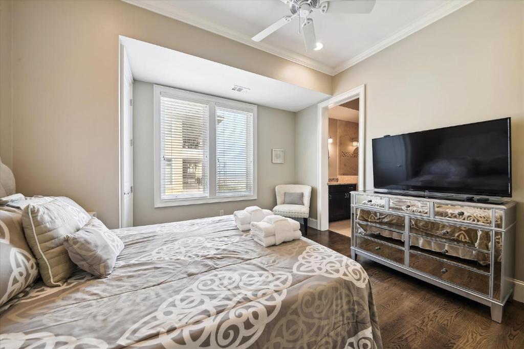 a bedroom with a large bed with a flat screen tv at 27 Singleton Beach- Oceanfront, Private Pool, Pool Table, FREE Activities Included in Hilton Head Island