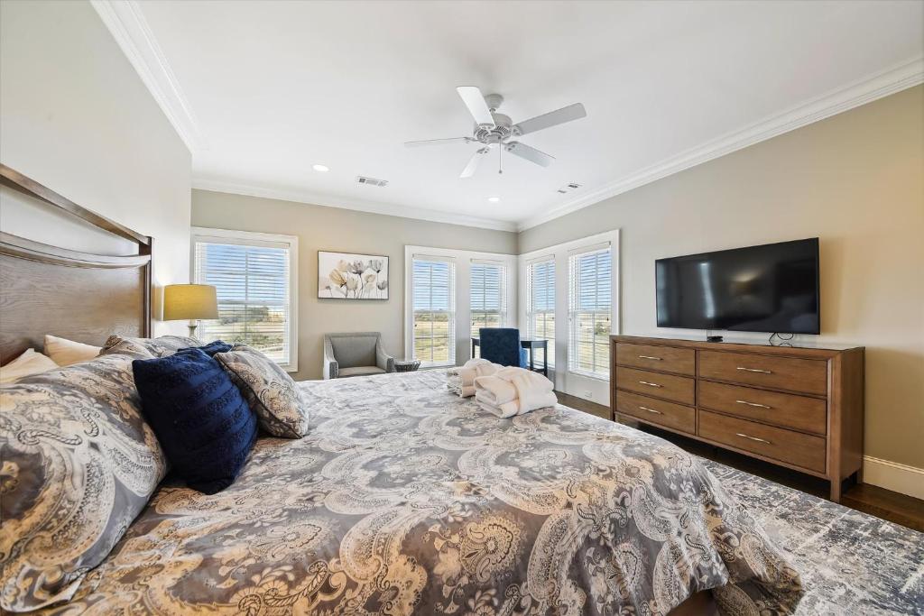 a bedroom with a large bed and a flat screen tv at 27 Singleton Beach- Oceanfront, Private Pool, Pool Table, FREE Activities Included in Hilton Head Island