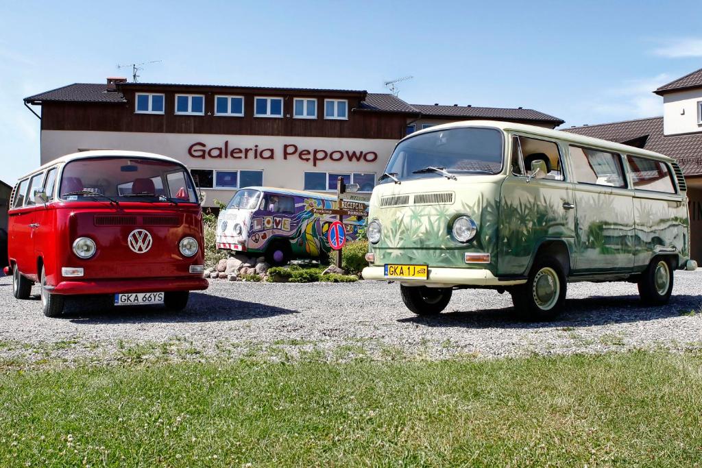 dos viejos autobuses VW estacionados en un estacionamiento en Galeria Pępowo, en Żukowo