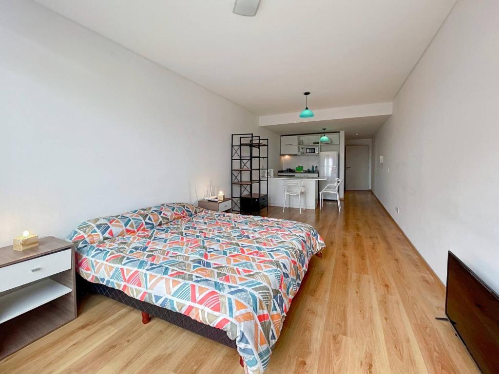 Un dormitorio grande con una cama y una cocina. en Spacious Studio in San Telmo with Balcony, Gym Pool, en Buenos Aires
