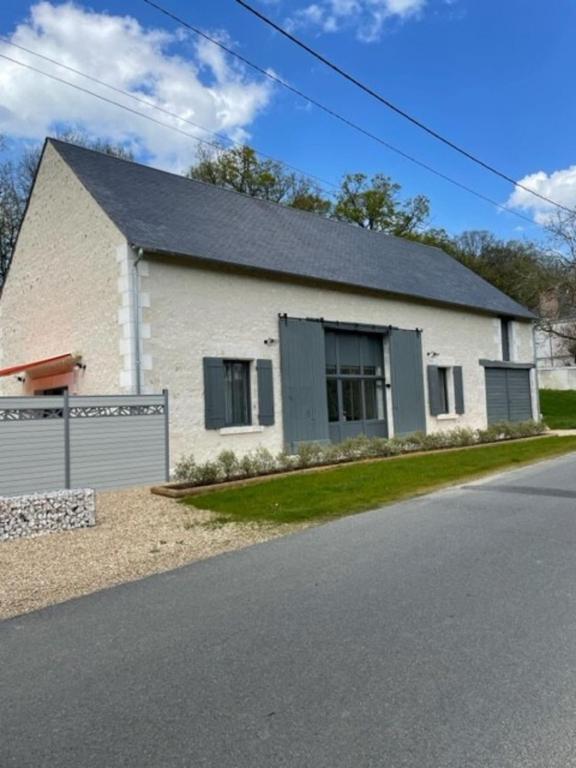 une maison en briques blanches avec un garage dans l'établissement La grange aux noix 20min du zoo près du plan d'eau, à Monthou-sur-Cher