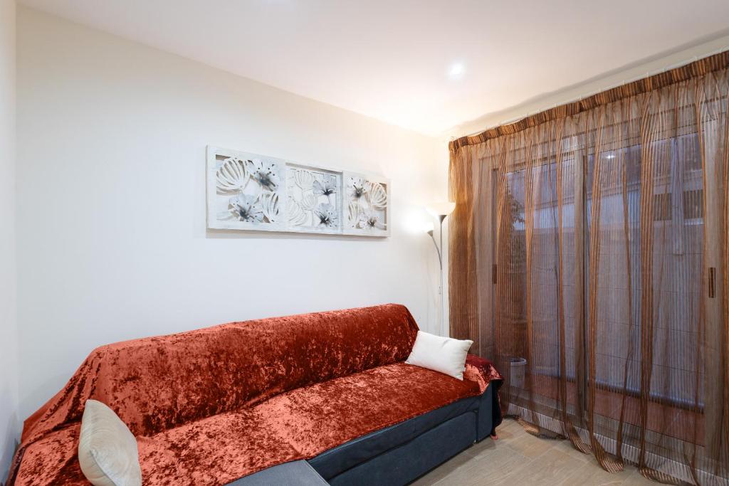 een woonkamer met een bank en een raam bij Bonito piso cerca de park guell in Barcelona