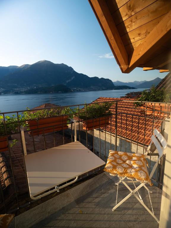 a table and a chair on a balcony with a view at Lakeview Jonny house on the roofs in Lezzeno