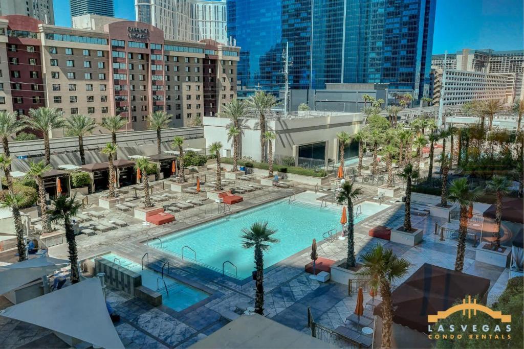 an overhead view of a pool with palm trees and buildings at MGM Signature-03-703 Strip View Jacuzzi Studio in Las Vegas