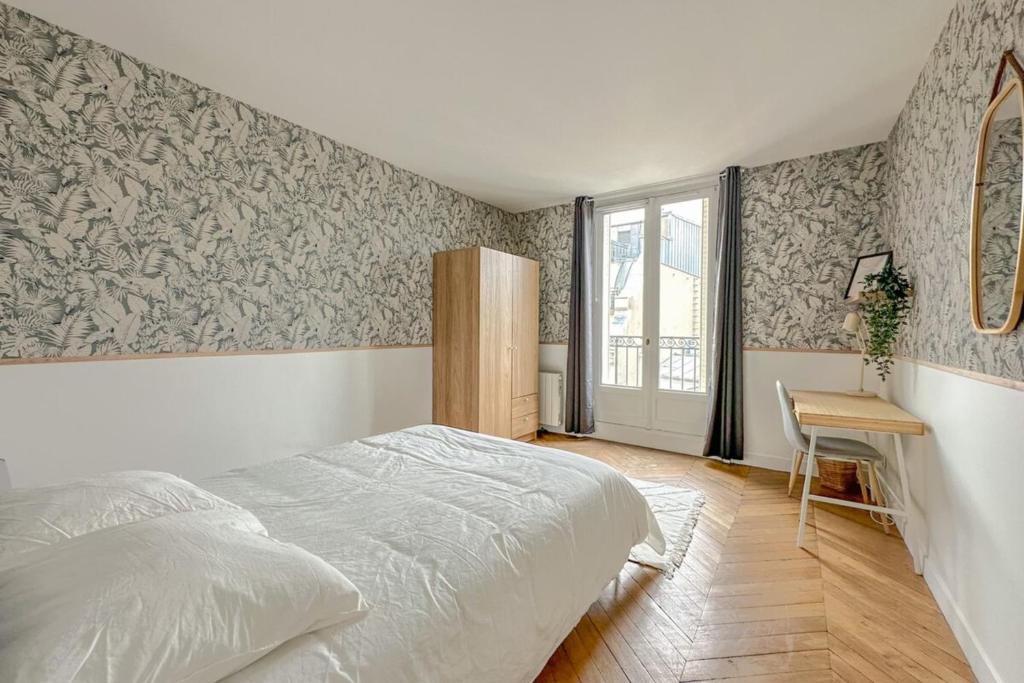 une chambre avec un lit, une table et une fenêtre dans l'établissement Flexliving - room - Septembre, à Paris