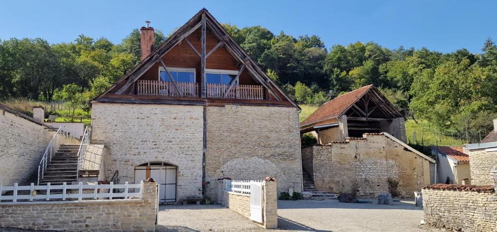 un gran edificio de ladrillo con un balcón en la parte superior. en Chambres d'Hôtes Chez Jean, en Spoy