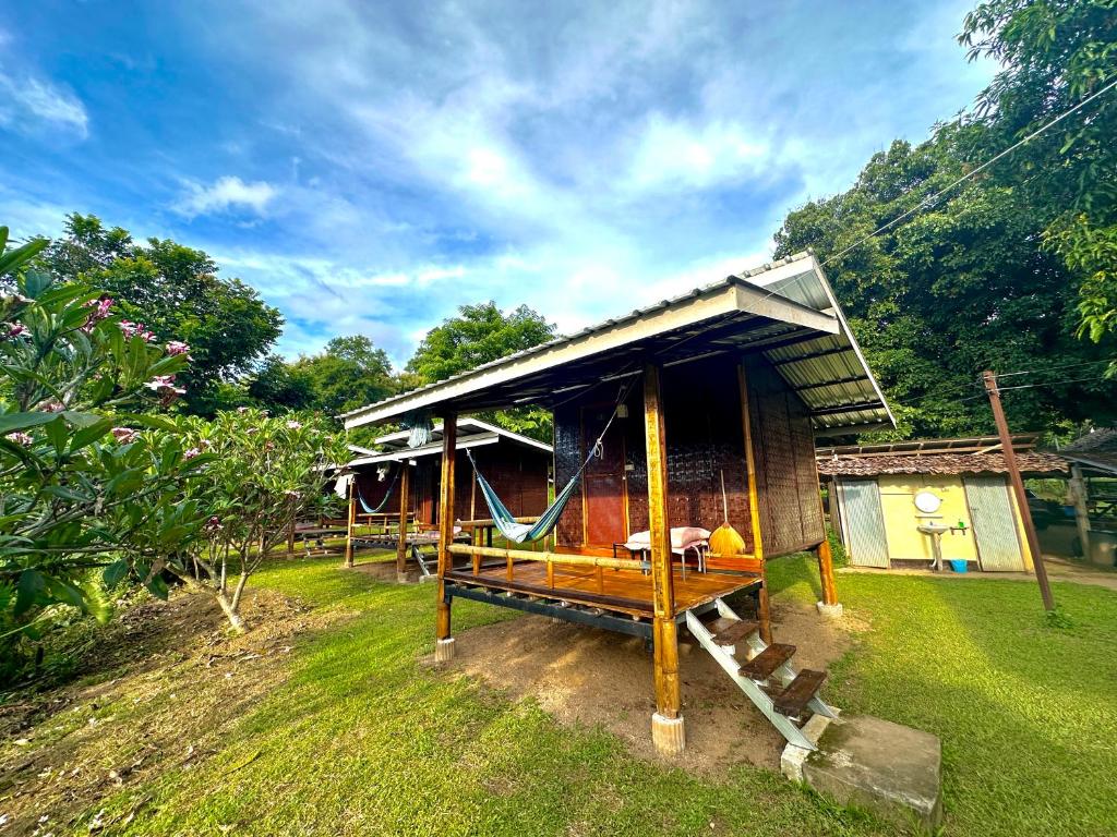 una pequeña casa con una hamaca en el patio en Twin Hut, en Pai