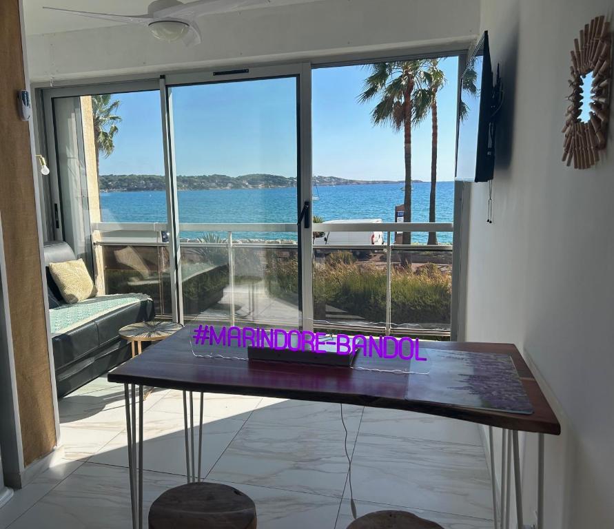 - une table dans une chambre avec vue sur l'océan dans l'établissement VUE MER ET A 20m DE LA PLAGE AVEC PARKING MARINDORE BANDOL, à Bandol