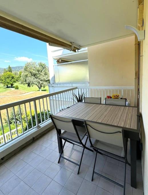 une terrasse couverte avec une table et des chaises en bois sur un balcon dans l'établissement 14475 deux pièces dans une résidence, à La Napoule-Plage