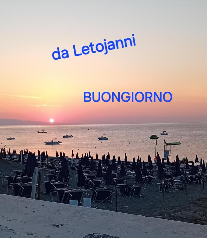 a beach with chairs and umbrellas at sunset at Perla de Mar a 20m dalla spiaggia in Letojanni
