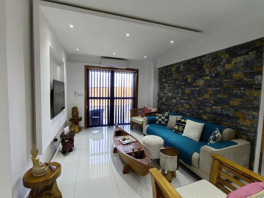 a living room with a blue couch and a table at Luxury Seaview Apartment Flic en Flac ASF4 in Flic-en-Flac