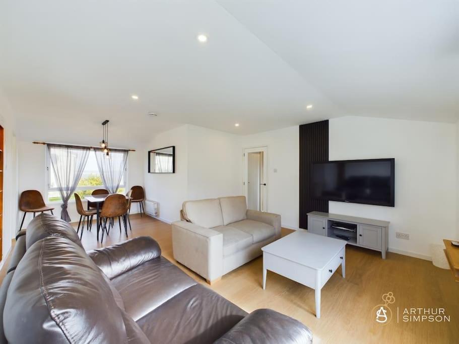 a living room with a leather couch and a table at 3 Bedroom House in Brae in Brae