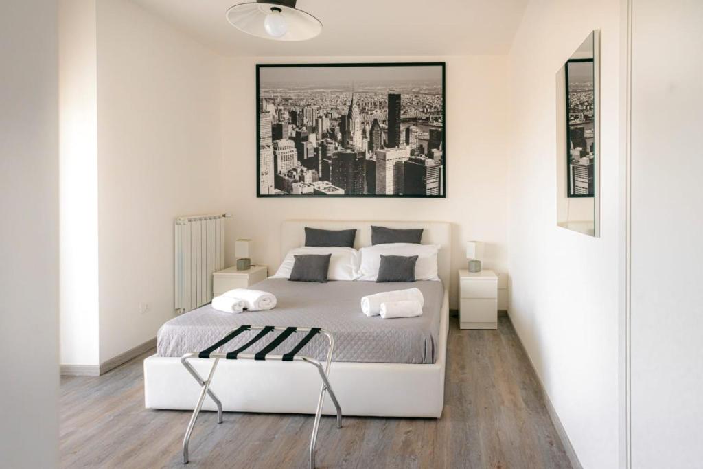 a white bedroom with a bed and a picture on the wall at Airport Bari palese LUXURY 2 in Bari
