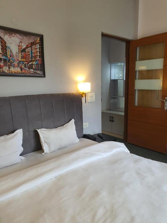 Postel nebo postele na pokoji v ubytování Mallenzo Suites Dlf Phase 1
