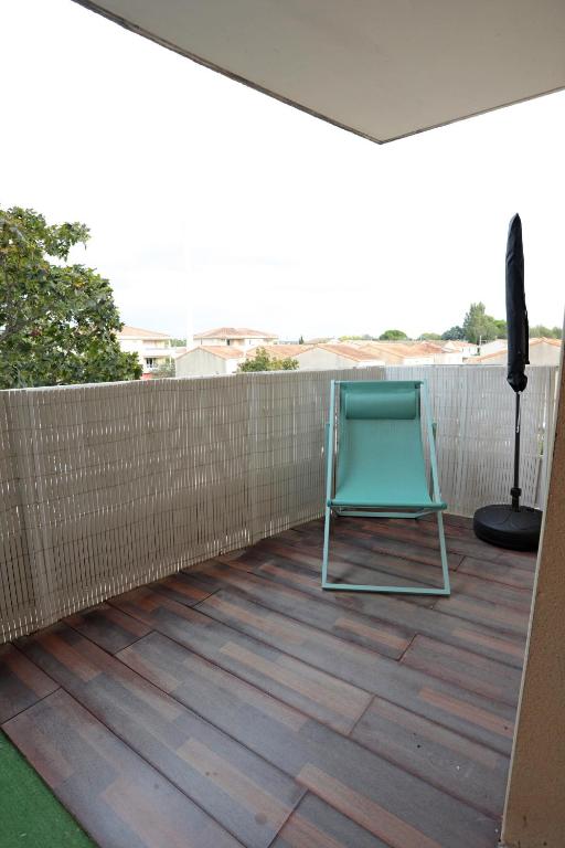 une chaise verte assise sur une terrasse avec une clôture dans l'établissement Appart T2 dans résidence calme Parking privé gratuit, à Miramas