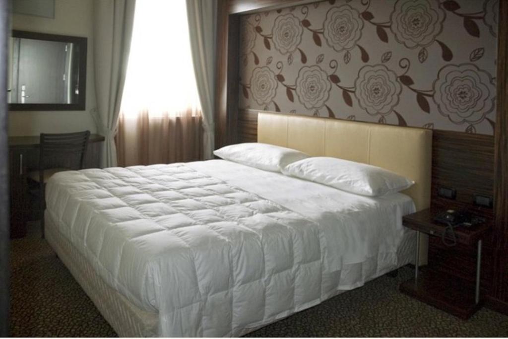 Postel nebo postele na pokoji v ubytování Hotel Novelli