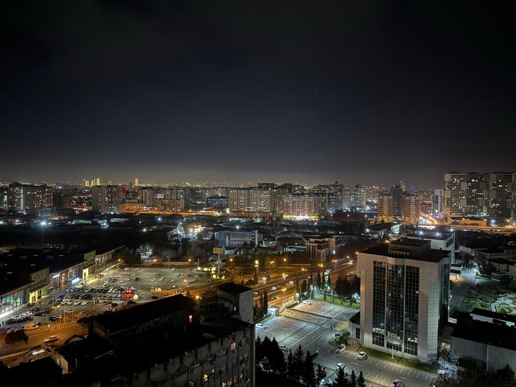 a view of a city at night with lights at Modern and Cozy Apartment in Baku in Baku