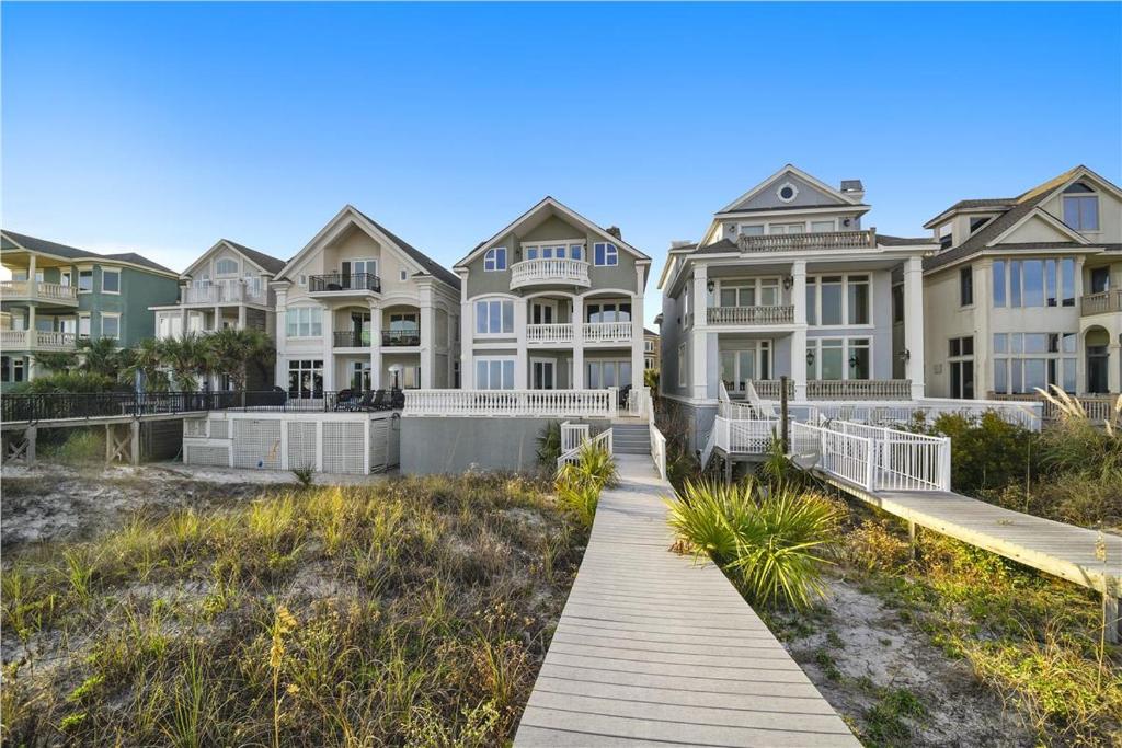 a row of houses on the beach with a boardwalk at 6 Collier Beach Road- Oceanfront, Large Pool, Elevator, FREE Activities Included in Hilton Head Island