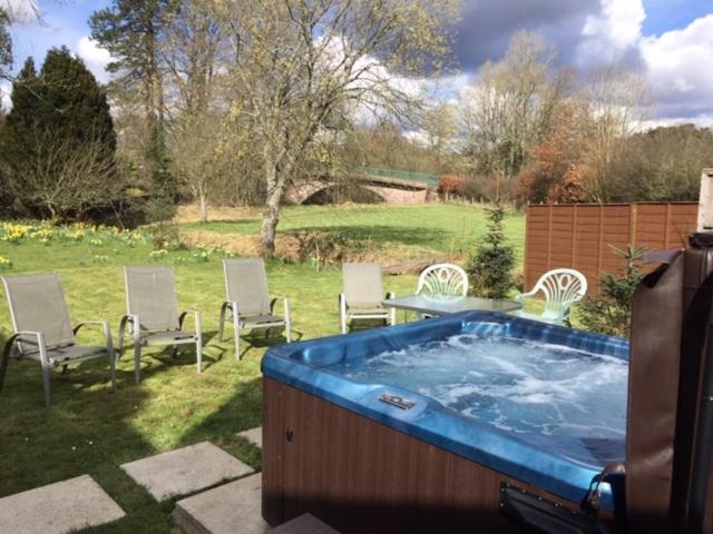a large hot tub in a yard with chairs at FREE HOT TUB use, Exclusive Idyllic Large Themed Cumbrian Mill Countryside 100s 5star most loved in Carlisle