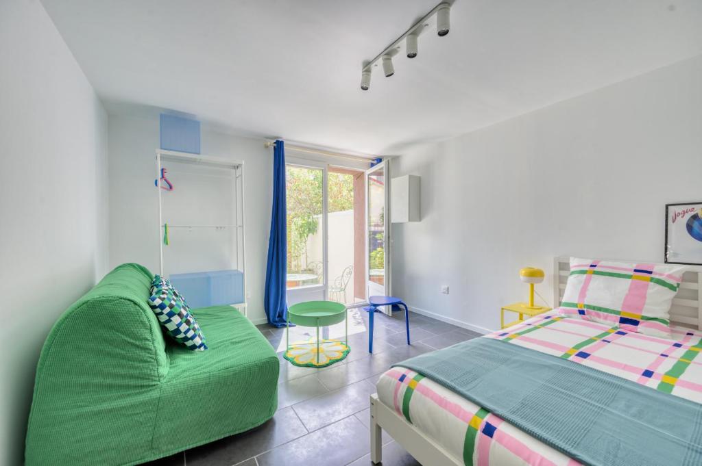 a bedroom with a green couch and a bed at Paris Orly Metro 7 et 14 in Villejuif