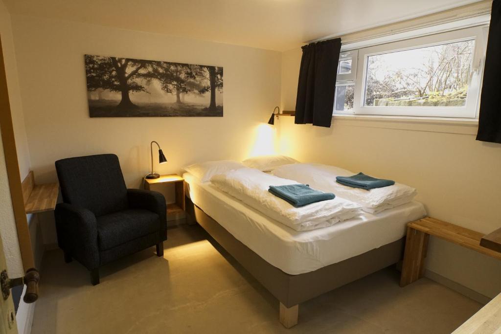 レイキャビクにあるMain street X-small, ensuite bathroom and own kitchenのベッドと椅子と窓のある寝室