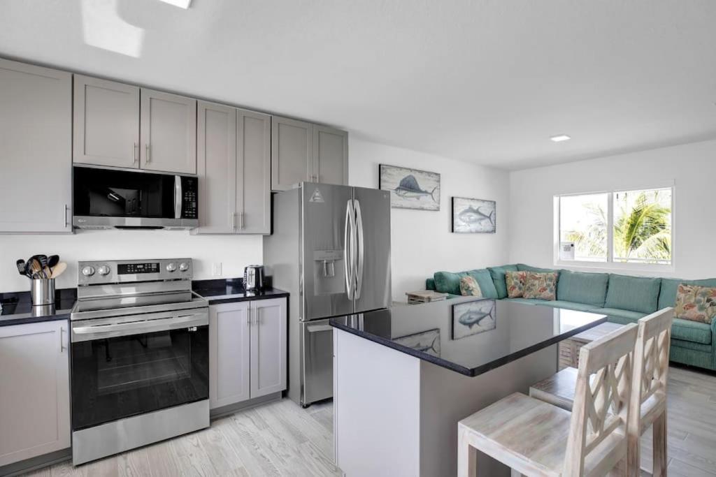 a kitchen with white cabinets and a stove top oven at Gated Oceanfront Heated Pool in Marathon