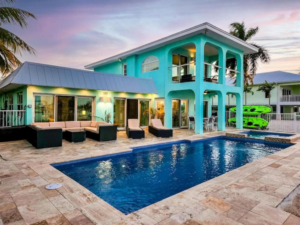 a house with a swimming pool in front of a house at Oceans Edge Retreat in Key Colony Beach