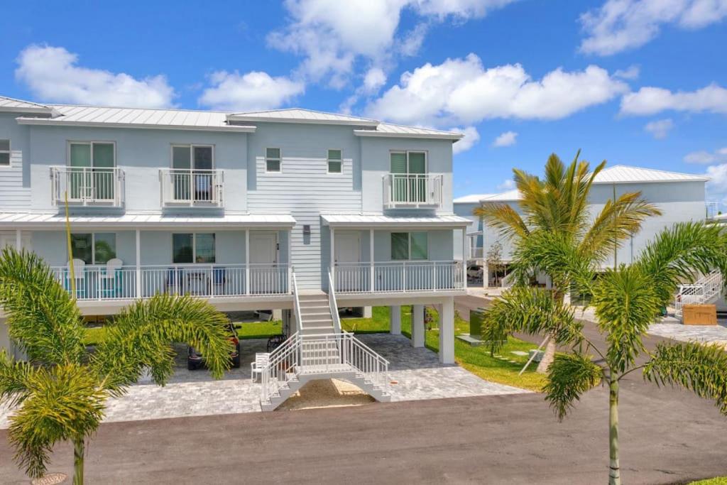 a white house with palm trees in front of it at Panoramic Ocean Views Galore in Marathon