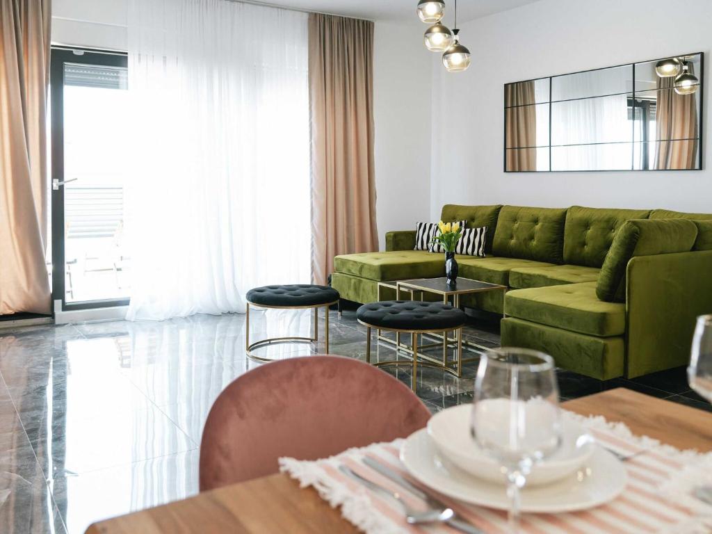 un soggiorno con un divano verde e un tavolo di Villa La Ze - Three Bedroom Villa with Swimming Pool a Rogoznica (Rogosnizza)