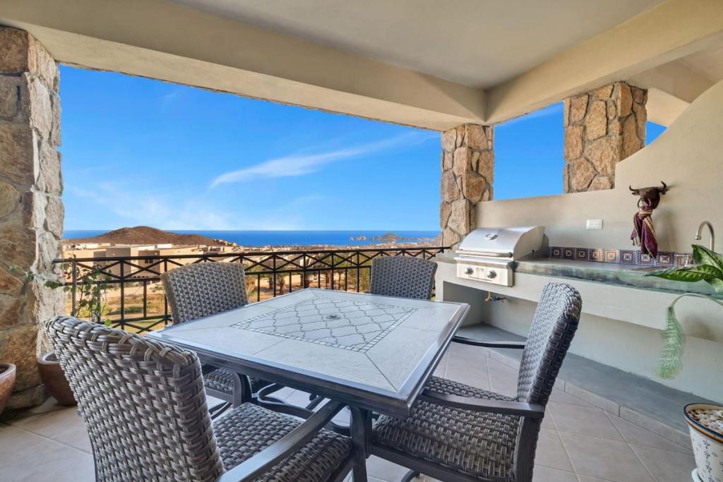 a table and chairs on a balcony with a view of the ocean at 2BD-2BA Condo at Ventanas 3B in Cabo San Lucas