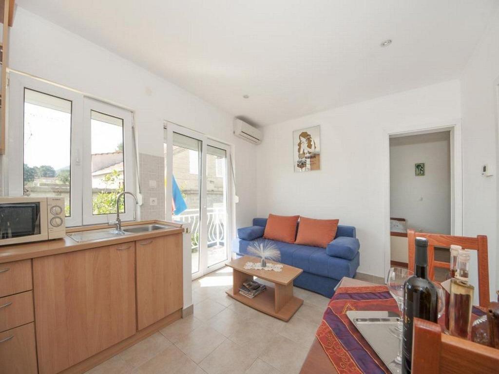 un soggiorno con un divano blu e una cucina di Bertie's Lodge - Comfort One Bedroom Apartment with Balcony and Sea View A3 a Smokvica