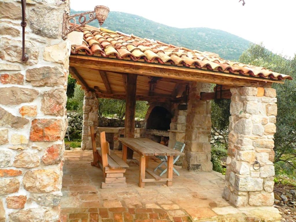 un abri en pierre avec une table en bois et un banc dans l'établissement Lavender Cottage-Two Bedroom Holiday Cottage with Terrace, à Trpanj