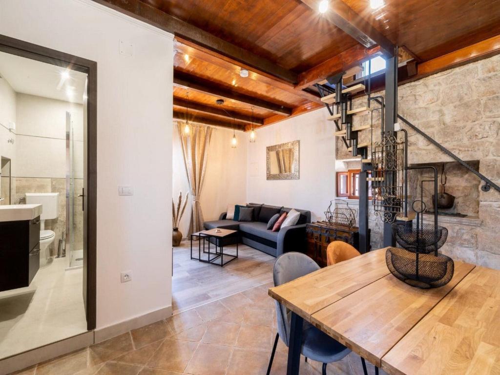 a living room with a wooden table and a couch at Stone House Prapatna-Two Bedroom Holiday Home with Swimming Pool in Smokvica