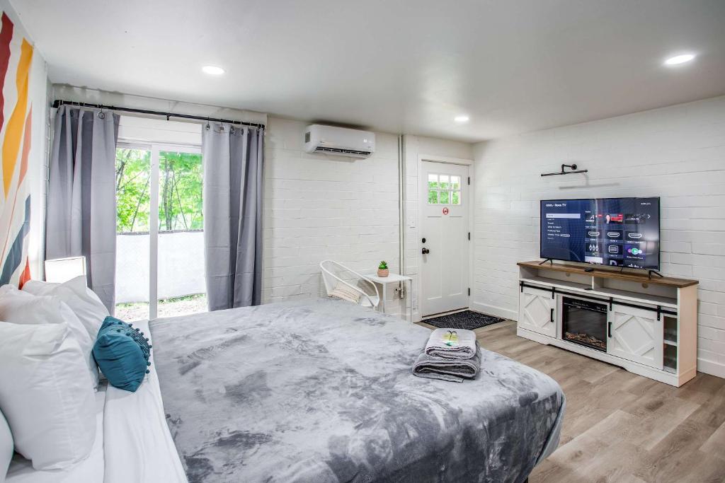 Un dormitorio con una cama grande y un televisor de pantalla plana. en Newly Renovated Bright Studio, en Rochester