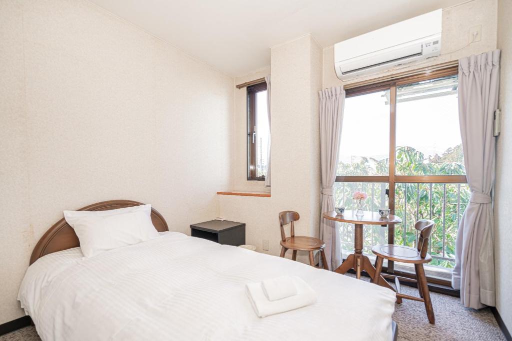 御殿場市にあるFujiminoyado - Vacation STAY 62143vのベッドルーム1室(ベッド1台、窓、テーブル付)
