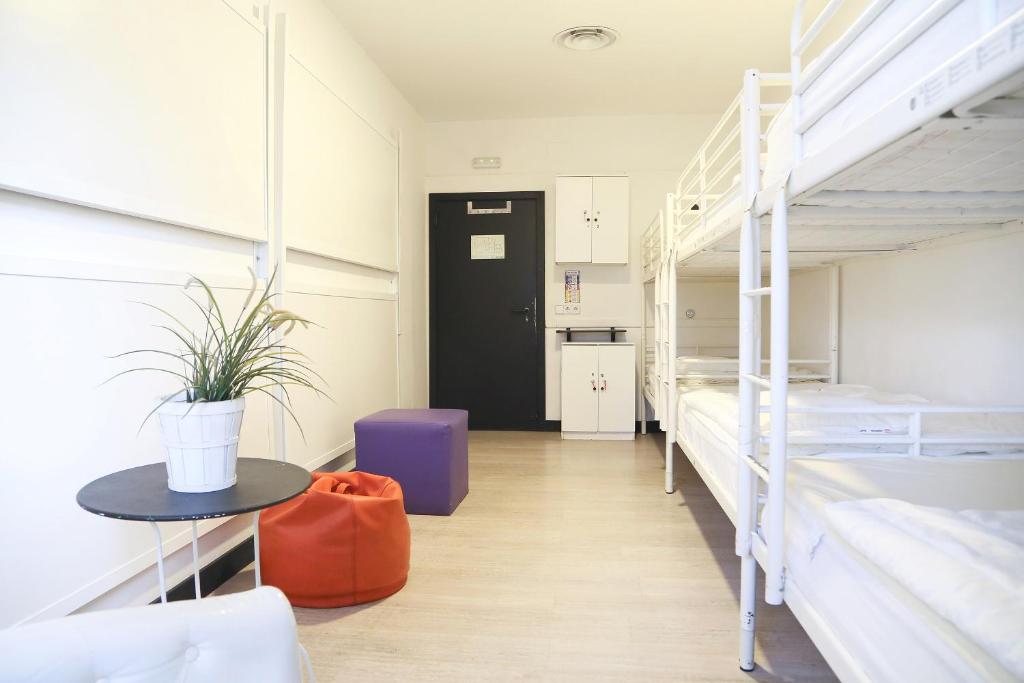 a dorm room with two bunk beds and a table at Hostels Meetingpoint in Madrid