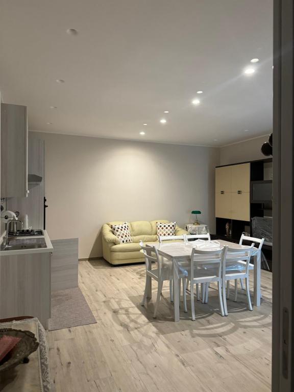 una cucina e un soggiorno con tavolo e sedie di Casa Erminia a Caserta