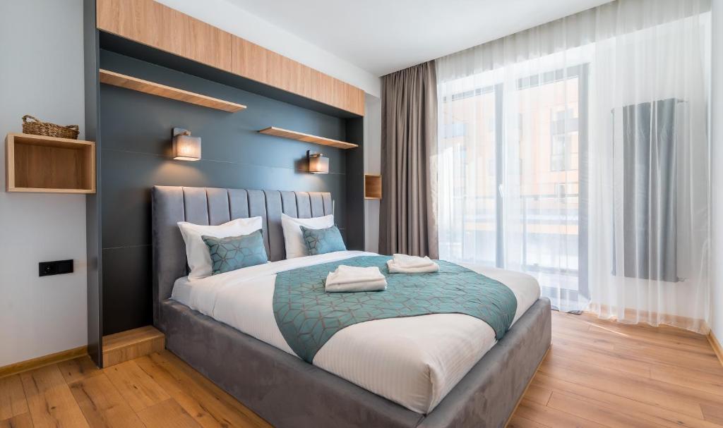 a bedroom with a large bed with a large window at New Gudauri Geoflats in Gudauri