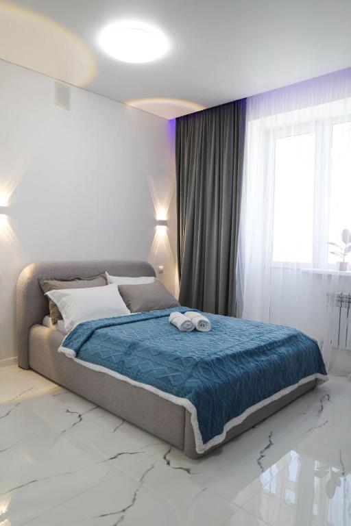 a bedroom with a bed with two towels on it at Бизнес-класса in Kostanay