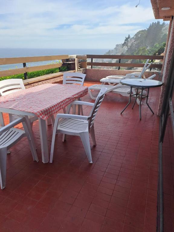 a patio with a table and chairs and the ocean at Reñaca Gran terraza con vista al mar in Viña del Mar